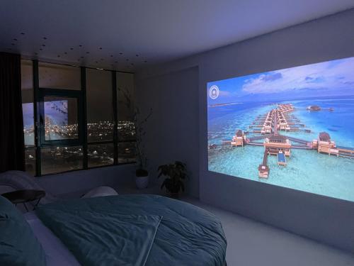 a bedroom with a large tv screen showing a resort at Studia-Focus-Design in Aktobe