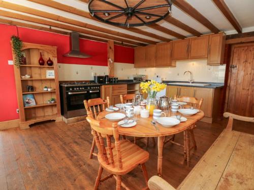 a large kitchen with a wooden table and chairs at The Farmhouse in Ciliau-Aeron