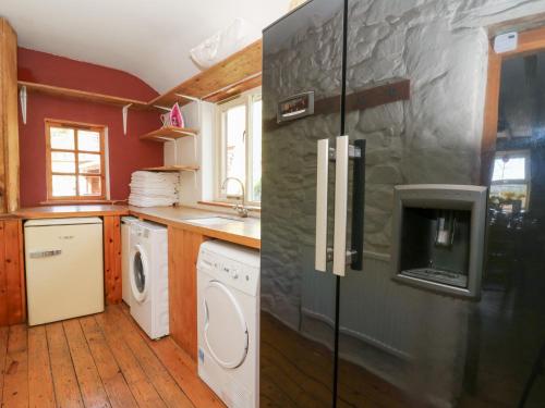 a kitchen with a refrigerator and a washer and dryer at The Farmhouse in Ciliau-Aeron