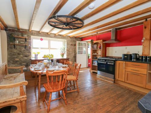 a kitchen with a table and chairs in a room at The Farmhouse in Ciliau-Aeron