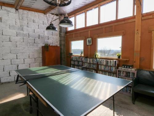 a ping pong table in the middle of a library at The Farmhouse in Ciliau-Aeron