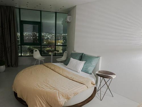 a bedroom with a bed with a view of a city at Studia-Focus-Design in Aktobe