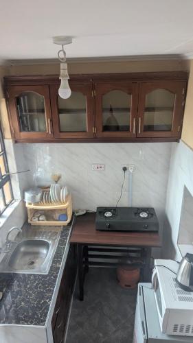 a kitchen with a counter with a sink and a stove at National Housing Estates in Kakamega