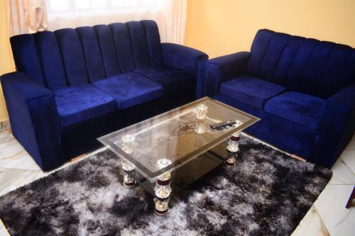 a living room with two blue couches and a coffee table at National Housing Estates in Kakamega