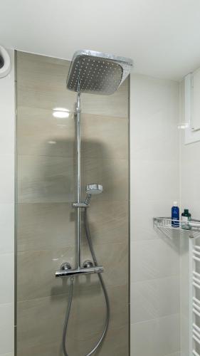 a shower with a shower head in a bathroom at LIMIDI HOMES - Spacious 2-Bedroom City Centre in Veliko Tŭrnovo