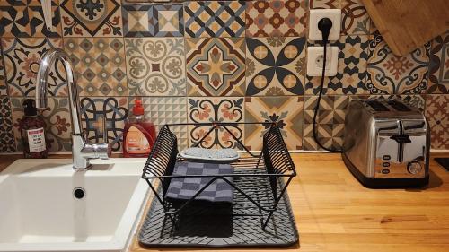 un évier de cuisine avec un égouttoir dessus dans l'établissement T4 souplex Authentique Toulousain, 5Pers 3lits- Tout équipé - hypercentre, à Toulouse