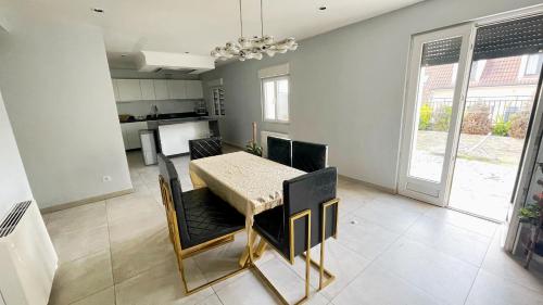 une cuisine et une salle à manger avec une table et des chaises dans l'établissement Maison Antony, à Antony