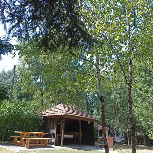 a pavilion with a picnic table and a bench at Ranch V8 Kosmaj in Rogača