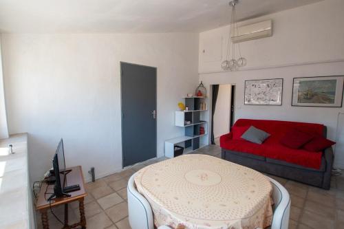 un salon avec un canapé rouge et une table dans l'établissement Julien - Terrasse avec vue époustouflante, à Arles