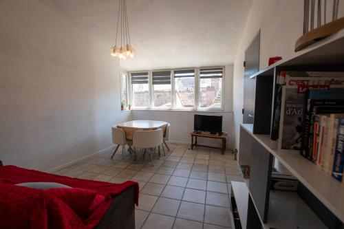 un salon avec une table et une télévision dans l'établissement Julien - Terrasse avec vue époustouflante, à Arles