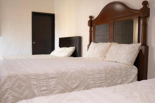 a bedroom with two beds with white blankets and pillows at Hotel El Dorado - cerca de Chapala y del Aeropuerto in Ixtlahuacán de los Membrillos