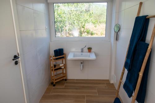 a small bathroom with a sink and a window at Quinta da Sra Marocas in Covilhã