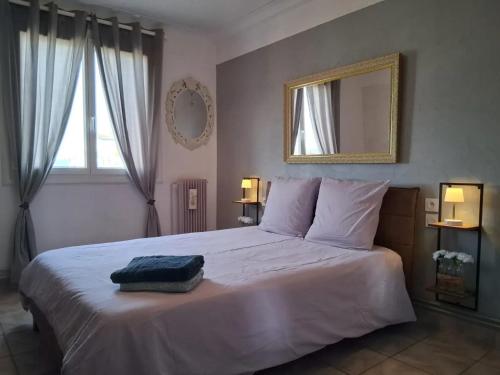 une chambre avec un grand lit blanc avec un miroir dans l'établissement Appartement moderne à Perpignan avec vue sur la montagne, à Perpignan