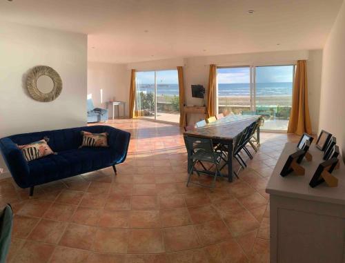 un salon avec un canapé bleu et une table dans l'établissement appartement spacieux front de mer, au Grau-du-Roi