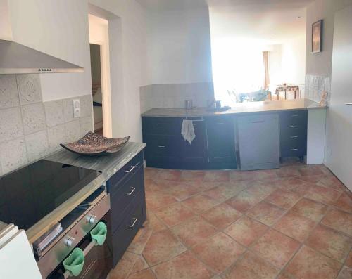 Il comprend une cuisine avec des placards bleus et du carrelage. dans l'établissement appartement spacieux front de mer, au Grau-du-Roi