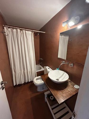 a bathroom with a white toilet and a sink at Chacras del Mar 4x4 in Mar Azul