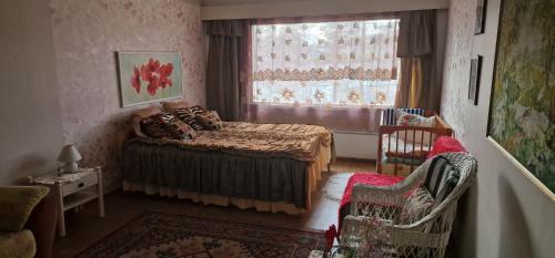 a bedroom with a bed and a window and chairs at Apartment Sorsakoski in Sorsakoski