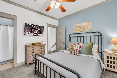 a bedroom with a bed and a ceiling fan at Cowbell Cottage in Starkville