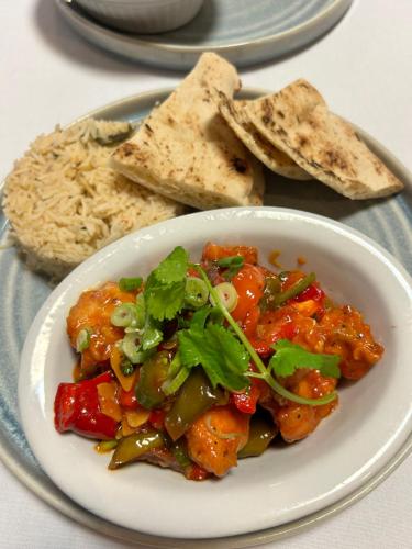 a plate of food with a bowl of food with rice at Crookston Hotel in Glasgow