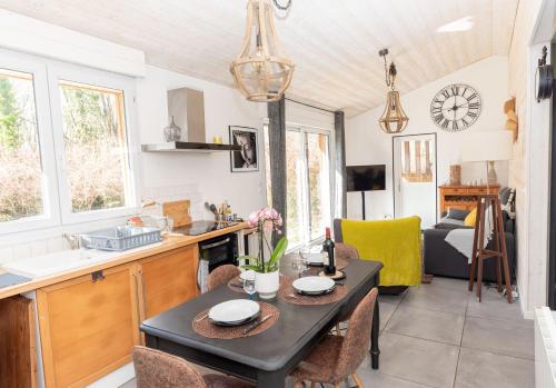 une cuisine et un salon avec une table et des chaises dans l'établissement Jolie Maison 84 m2 Océan Bordeaux Médoc Châteaux, à Salaunes