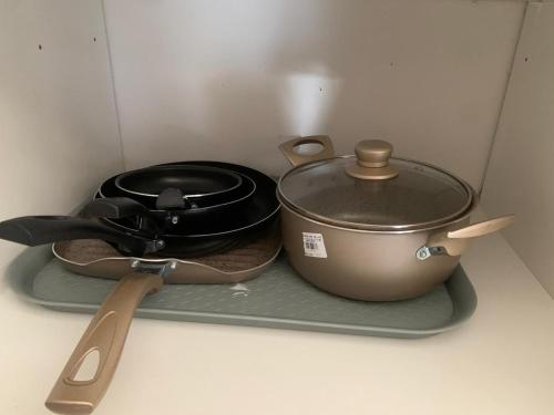 a pot and a pan sitting on a tray next to a pot and spatula at Hermoso apartamento con Piscina cerca al Parque Tayrona y Minca in Santa Marta