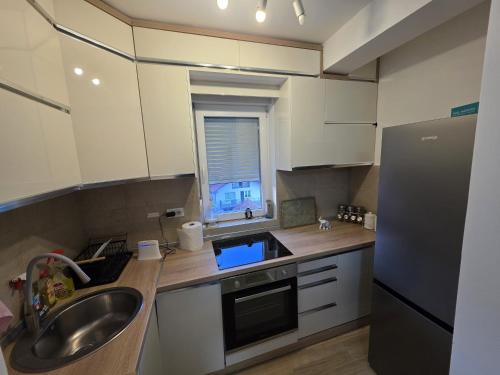 a small kitchen with a sink and a refrigerator at Relje krilatice in Novi Pazar