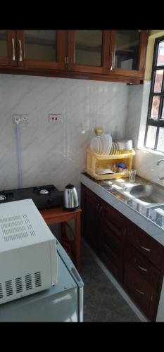 a kitchen with a counter top with a sink and a microwave at National Housing Estates in Kakamega