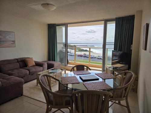 a living room with a table and chairs and a couch at Ebbtide 13 in Forster