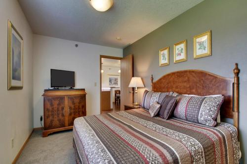 a bedroom with a large bed and a flat screen tv at Nauvoo Vacation Condos and Villas in Nauvoo