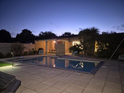una piscina davanti a una casa di notte di Maison de la villa à la fosse à l'âne 5 chambres a Le Fuilet