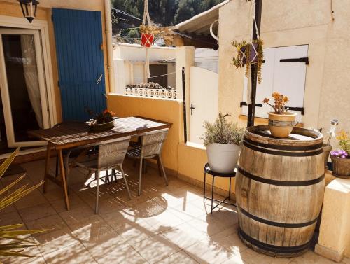 d'une terrasse avec une table, une table et un tonneau. dans l'établissement Cabanon dans la calanque de la Vesse, à Le Rove
