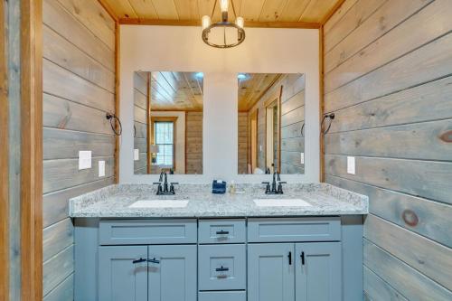 a bathroom with two sinks and a mirror at Modern and Cozy 5BR Family Cabin with Private Pool, Hot Tub, Pool Table, Fire Pit & Cozy Mountain Vibes in Sevierville