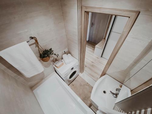 a white bathroom with a toilet and a sink at Apartmán Južná trieda in Košice