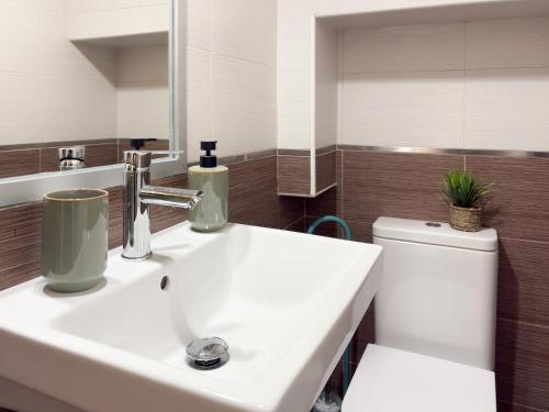 カンデレダにあるChillaHomes 203の白い洗面台とトイレのあるバスルーム