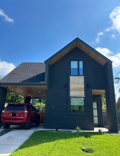 a blue house with a car parked in front of it at The Overlook in east Austin in Austin