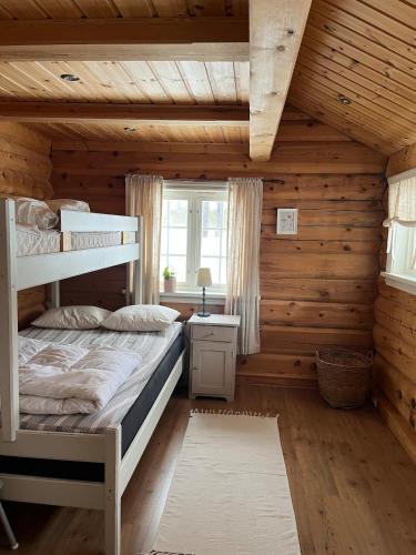 a bedroom with two bunk beds in a log cabin at Large and beautiful cabin in Løfald