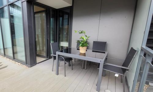 a table with chairs and a potted plant on a balcony at Hanza Tower 615 in Szczecin
