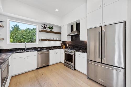 a kitchen with white cabinets and stainless steel appliances at The Overlook in east Austin in Austin