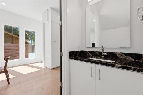 a white kitchen with a sink and a mirror at The Overlook in east Austin in Austin