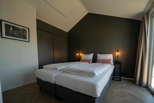 una camera con un letto con una parete nera di De IJssel Eilanden Chalet Casa Kampen mit Zaun Nr 548 a Kampen