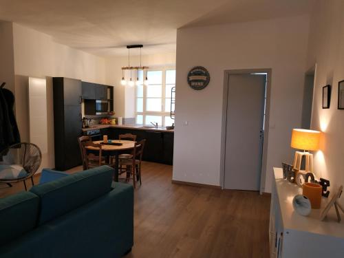 a living room with a couch and a table and a kitchen at maison du bord de Loire Ancenis in Ancenis