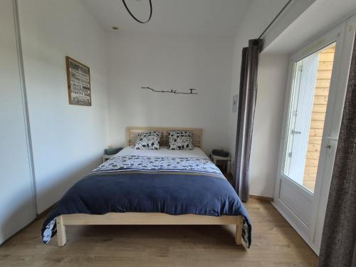 a bedroom with a bed in a room with a window at maison du bord de Loire Ancenis in Ancenis