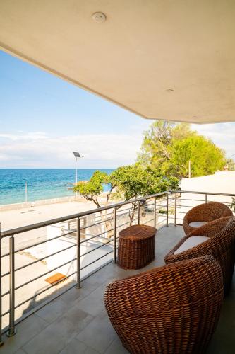 a balcony with chairs and a view of the ocean at Etesians Seaside House in Ágios Konstantínos