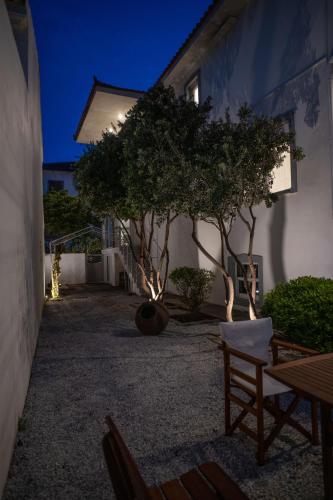 a building with trees in a courtyard at night at Etesians Seaside House in Ágios Konstantínos