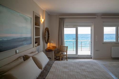 a bedroom with a bed and a view of the ocean at Etesians Seaside House in Ágios Konstantínos