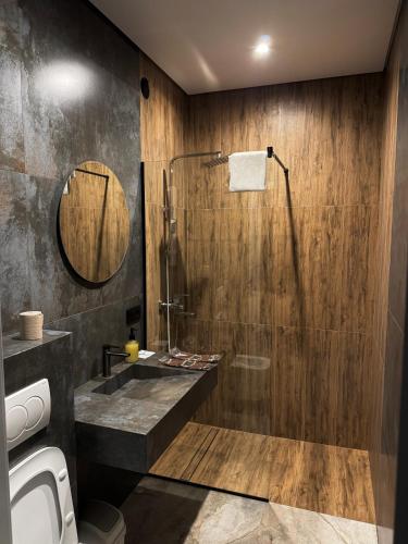une salle de bain avec douche et lavabo dans l'établissement Moyenne Apart Hotel, à Rivne