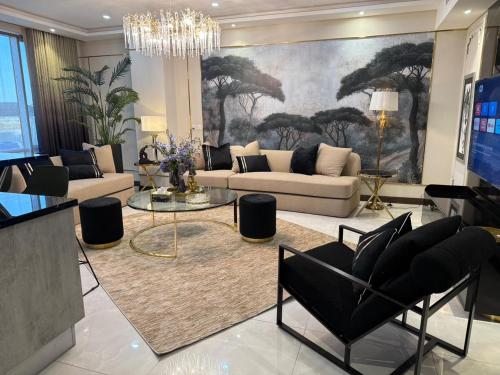 a living room with a couch and chairs and a chandelier at Oyster court gulberg in Lahore