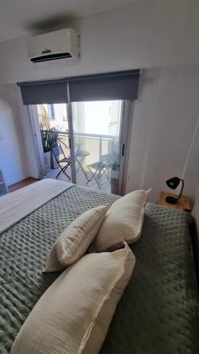 a bedroom with a bed with pillows and a window at Muy Hermoso Departamento en Recoleta in Buenos Aires
