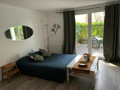 - une chambre avec un lit, une table et une terrasse dans l'établissement Terrasse Vilmer, Studio 3 personnes, Hyper centre, terrasse & parking, à Villers-sur-Mer