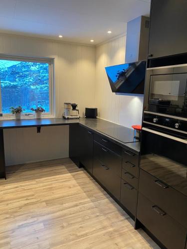 a kitchen with a counter and a large window at House in Vågan in Hopen